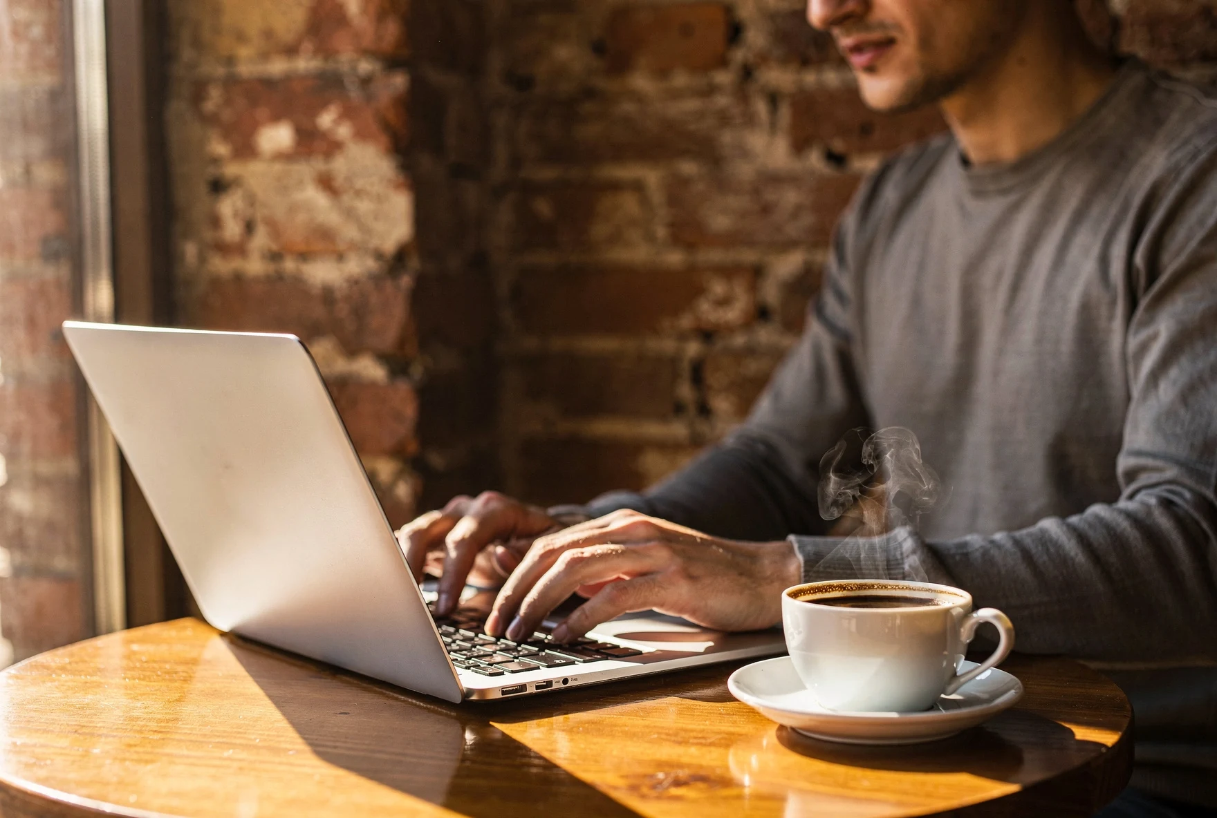 Person working on a laptop at a sunlit café in Tbilisi