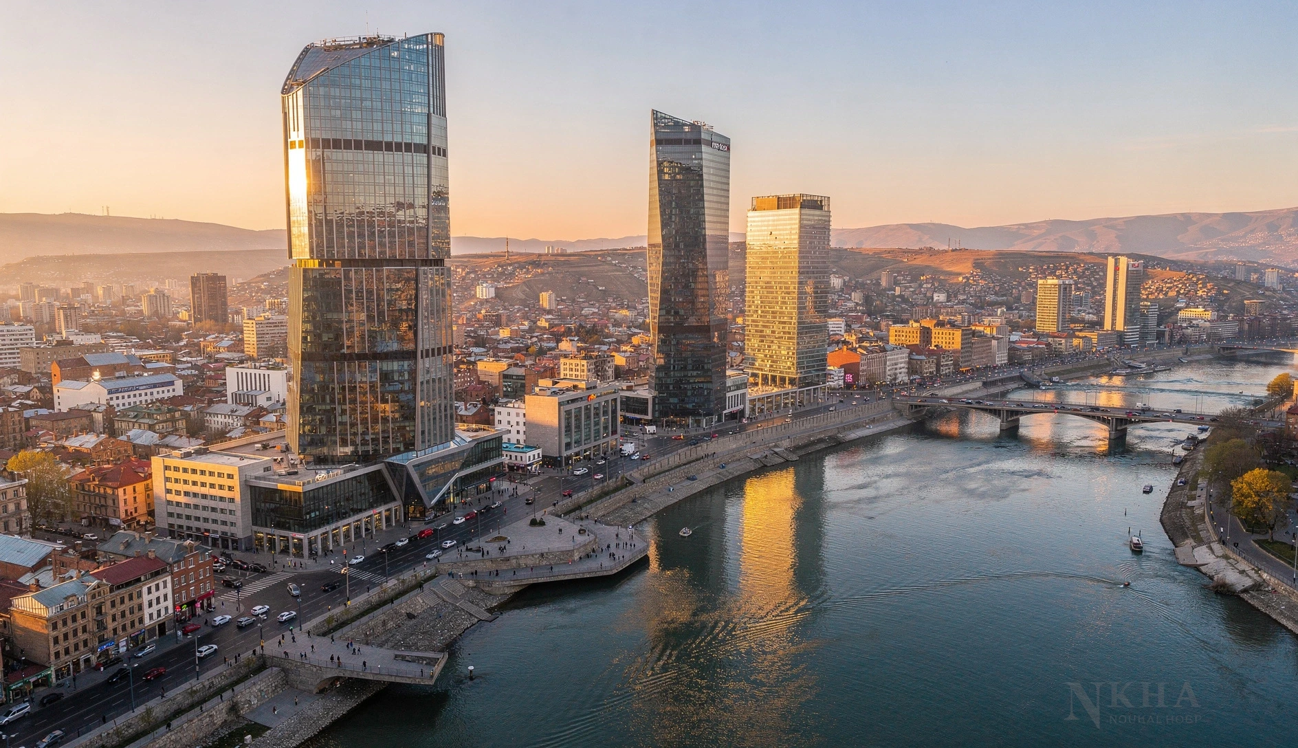 Aerial view of modern Tbilisi skyline at golden hour with the Kura River