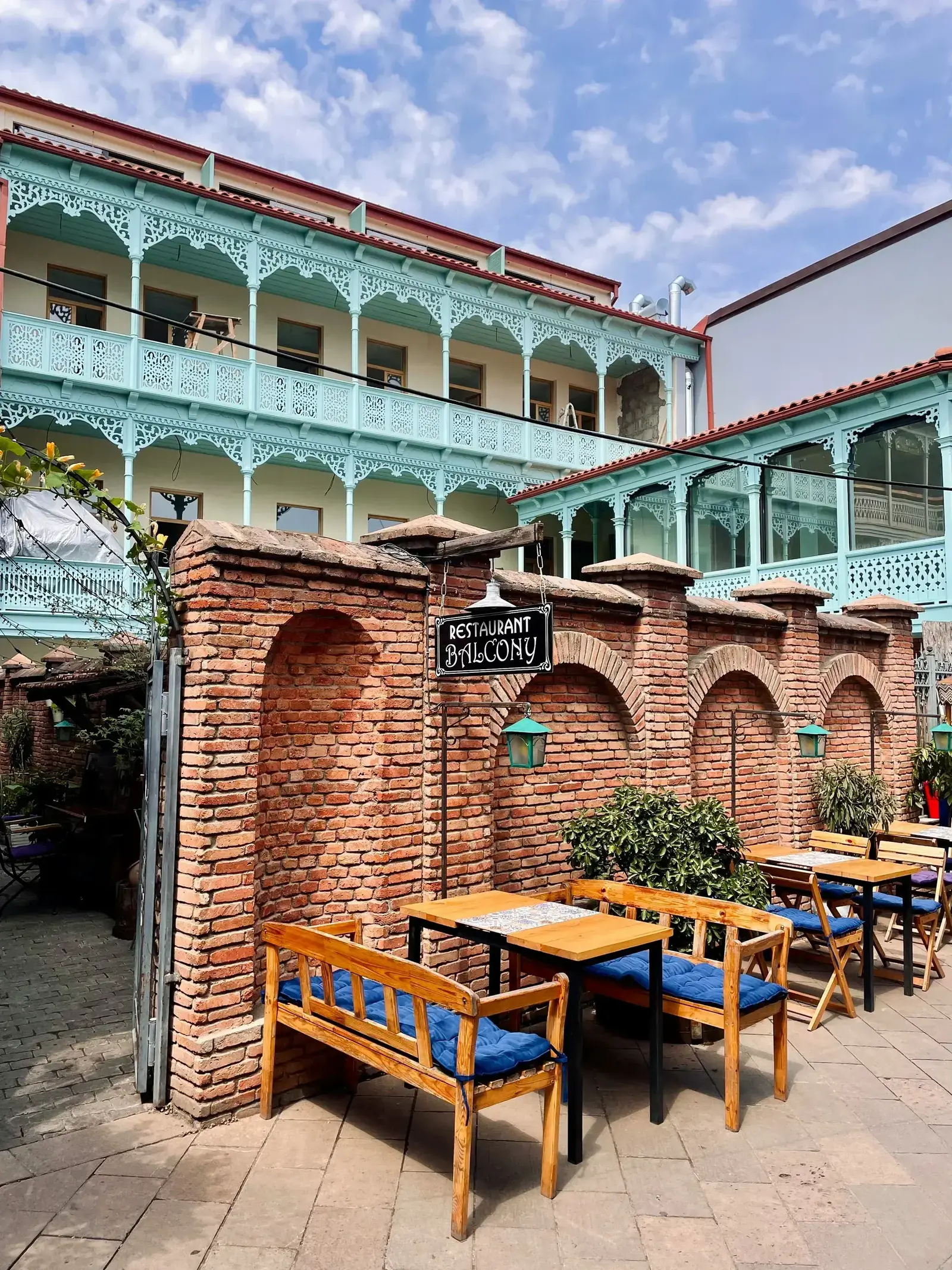 Traditional Georgian restaurant with ornate wooden balconies and outdoor seating in Tbilisi's Old Town