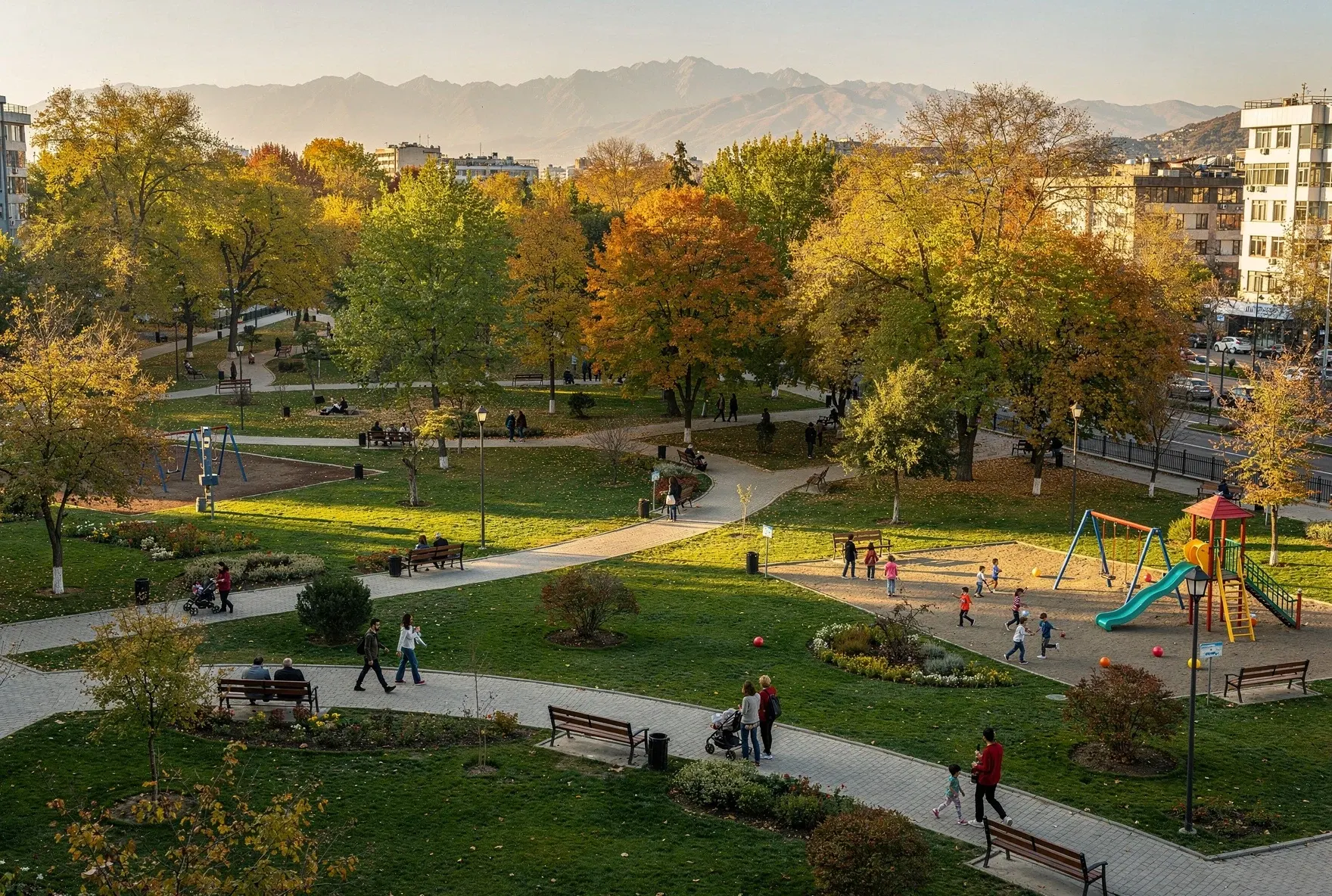 Aerial view of a green park in Tbilisi with families walking and children playing among autumn trees