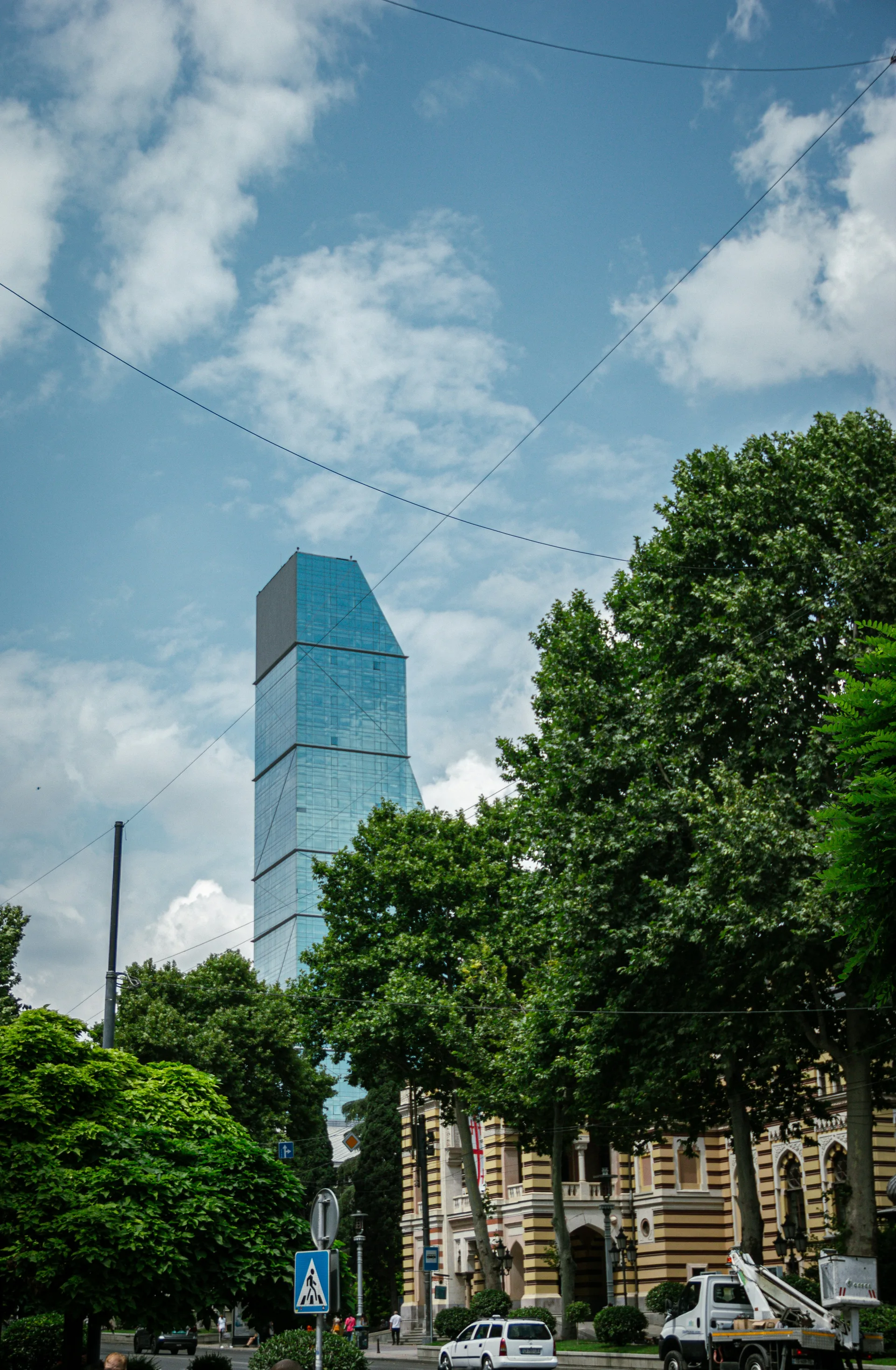 Modern Tbilisi street with glass skyscraper alongside 19th-century architecture in Vake area