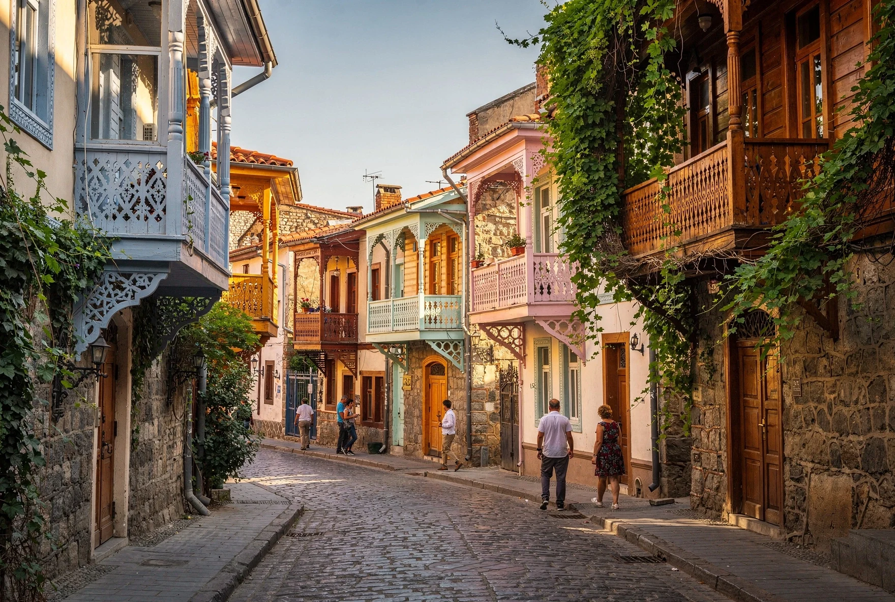 Tbilisi street scene with traditional balconies and people walking on a sunny day