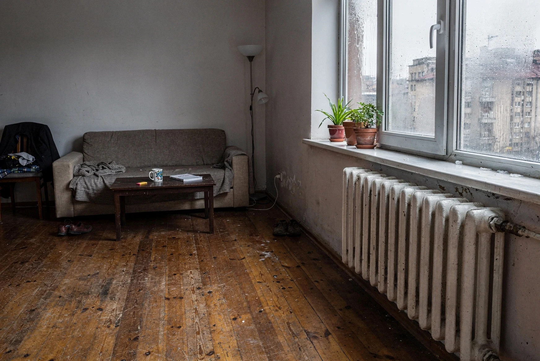 Older Tbilisi apartment interior in winter with radiator under a fogged window
