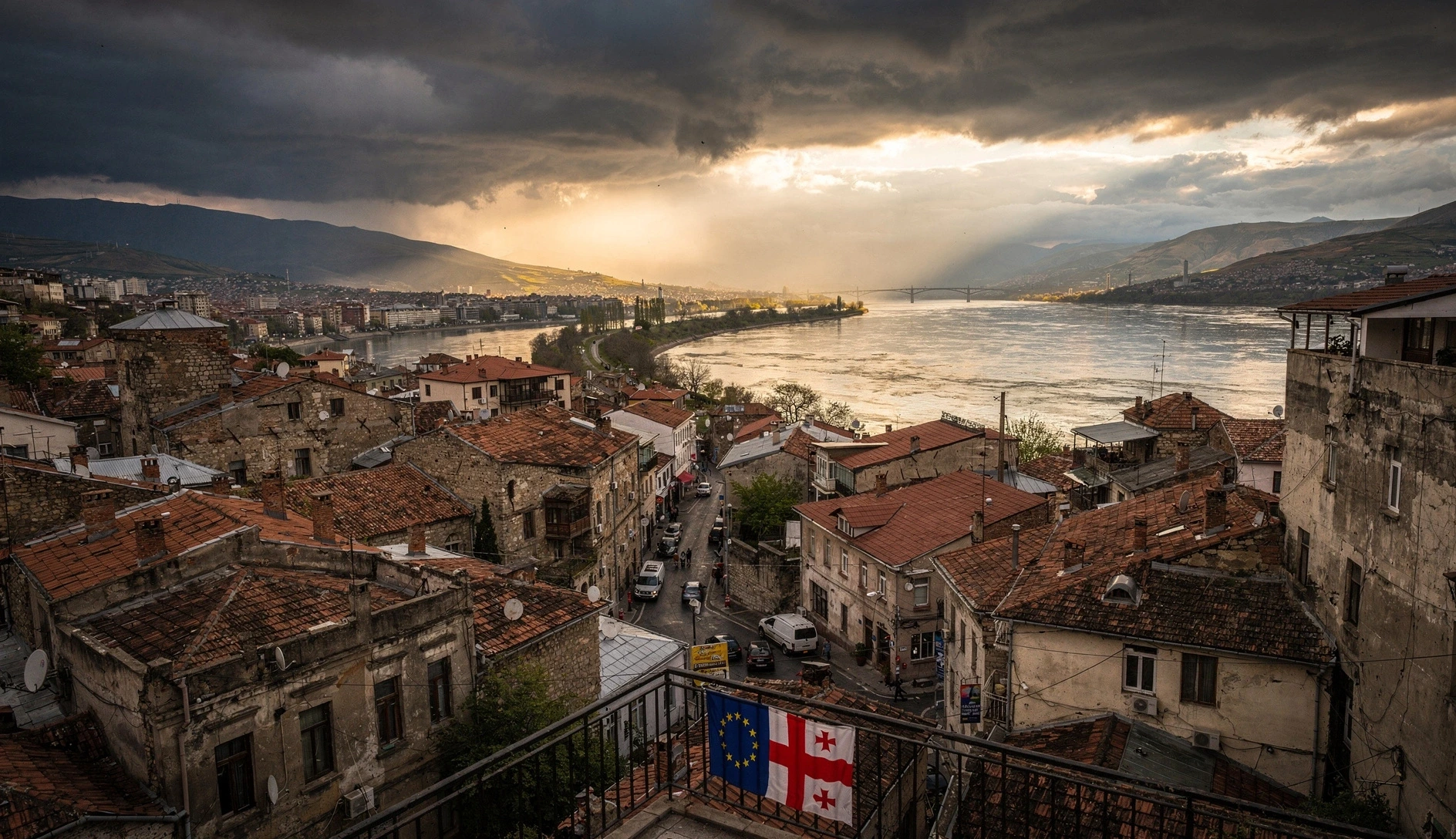 Aerial view of Tbilisi old town with Georgian and EU flags on a balcony at golden hour
