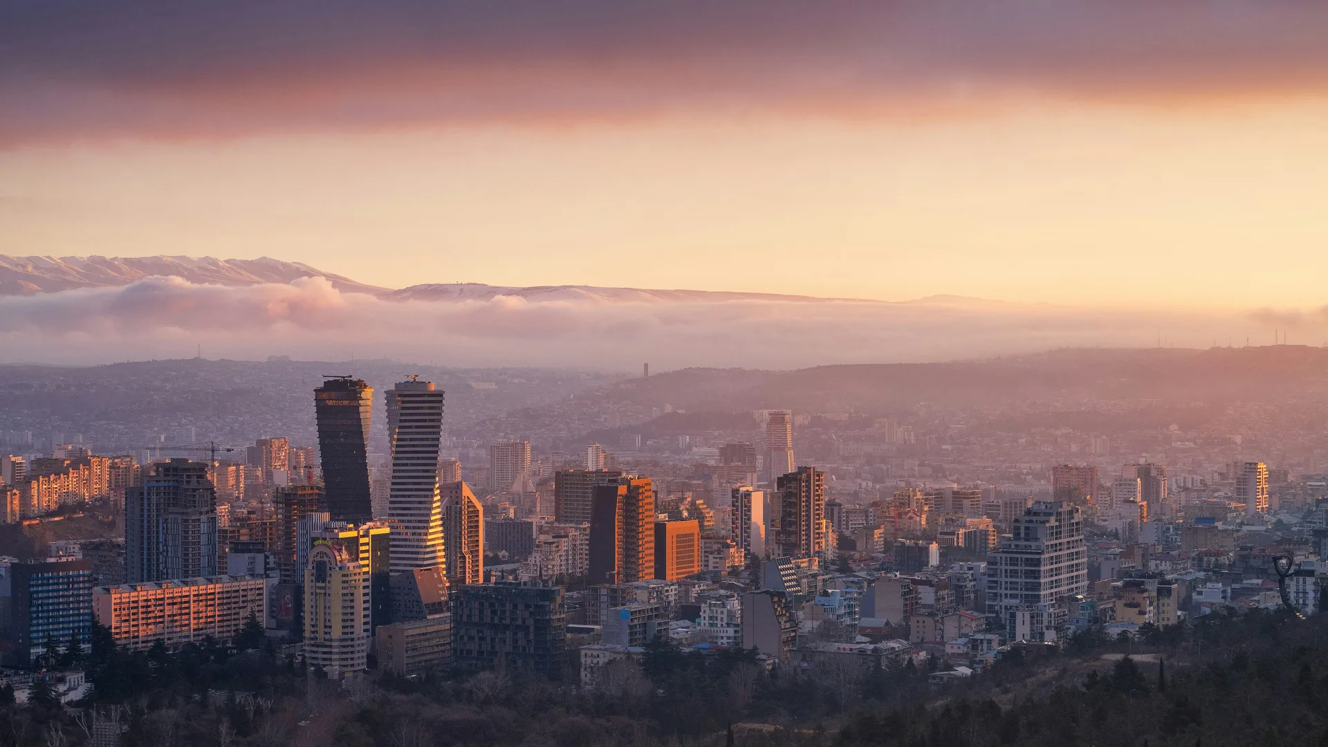 Modern Tbilisi skyline in Vake district at sunset with Caucasus mountains in the background