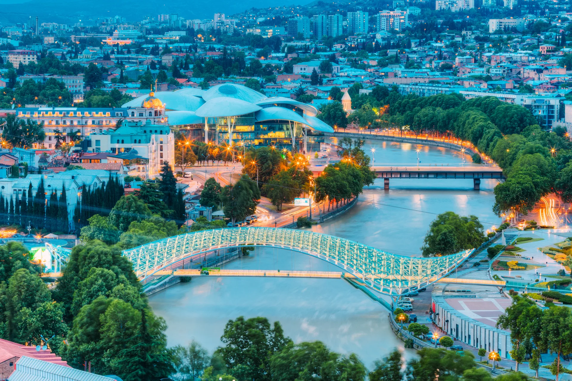 Aerial twilight view of Tbilisi with the Bridge of Peace illuminated over the Kura River
