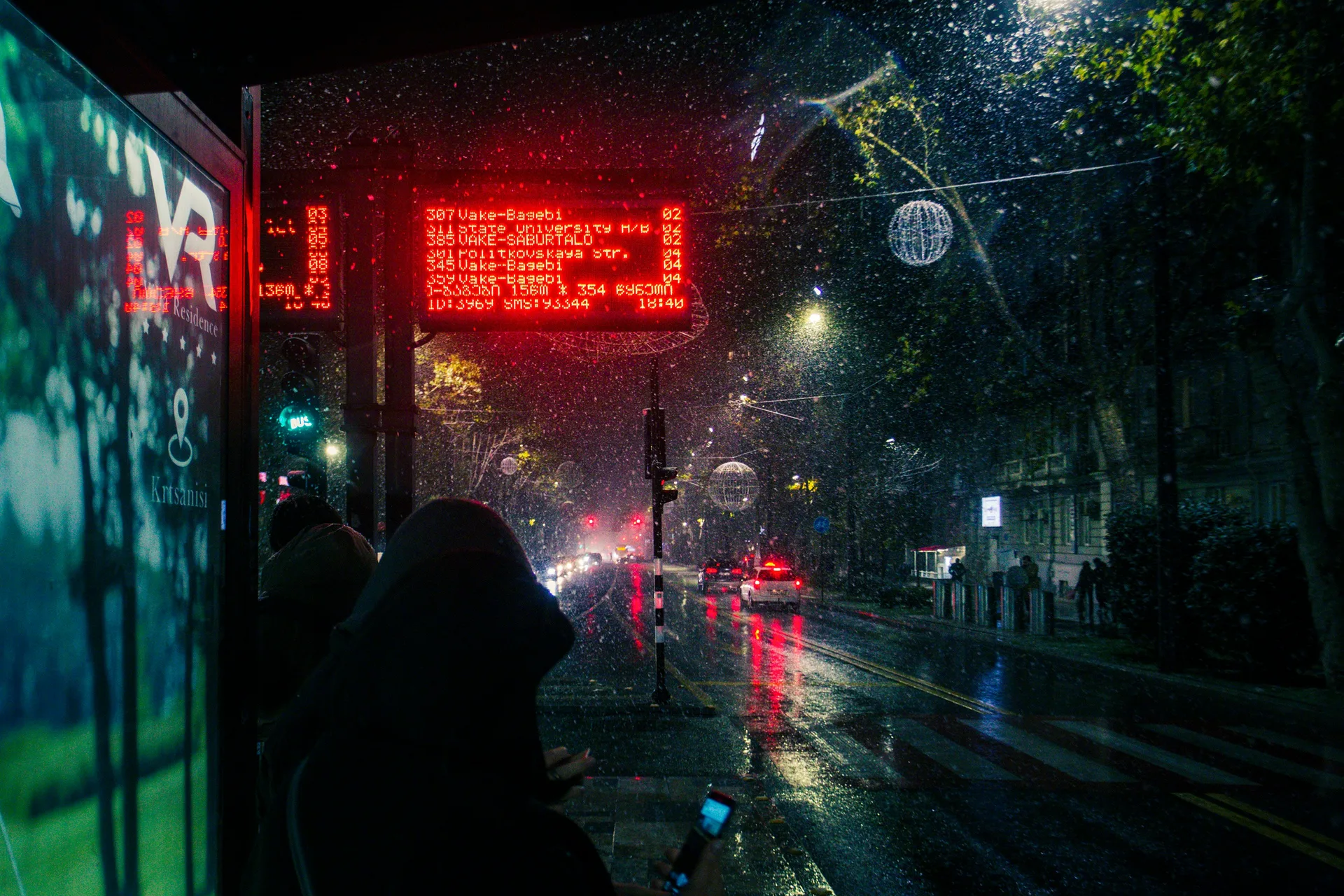 Bus stop in Tbilisi on a winter evening with digital display