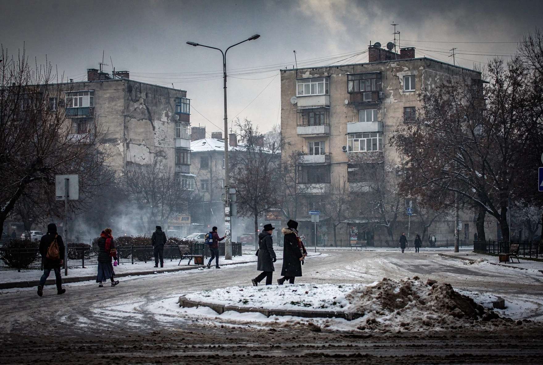 Tbilisi street in winter with snow on the ground and bare trees along a boulevard